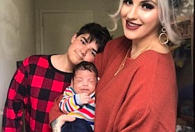 Allia Campbell with her newborn son Isaiah in her arms and 12-year-old son Landyn at their home in Kitchener, Ont. Originally from Cape Breton, Campbell is hoping Air Canada will reverse their decision to not refund their airline tickets. CONTRIBUTED 