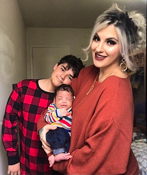 Allia Campbell with her newborn son Isaiah in her arms and 12-year-old son Landyn at their home in Kitchener, Ont. Originally from Cape Breton, Campbell is hoping Air Canada will reverse their decision to not refund their airline tickets. CONTRIBUTED 
