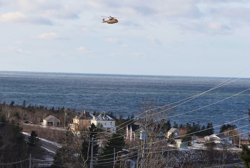A Cormorant SnR helicopter searches Wednesday near Parker's Cove, N.S. for the five remaining crew members of the Chief William Saulis, which sank Tuesday. TIM KROCHAK PHOTO
