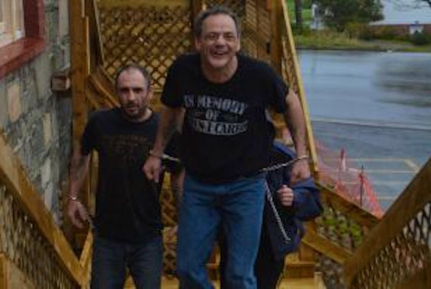 ['Wade Slade (left) and Paul Hanlon are led into provincial court in Harbour Grace on Oct. 26.']