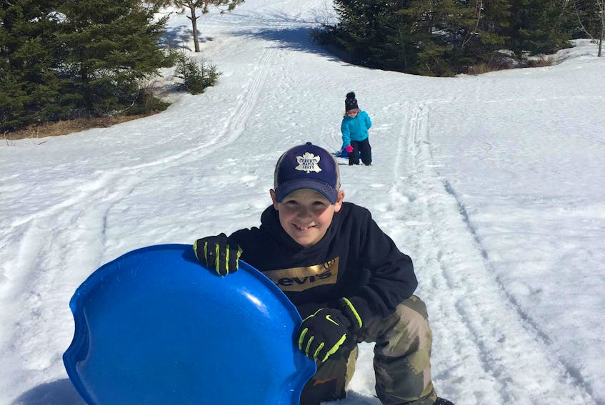 Nine-year-old Sam Graves was happy to be outside sledding with his family last week in their backyard in Marion Bridge. This was one of the activities the family has been doing together during self-isolation as a COVID-19 precaution. Although the family hasn't travelled outside of Nova Scotia, they've  been following recommendations from Nova Scotia's chief medical officer to stay away from public places since they were announced on March 15. CONTRIBUTED 