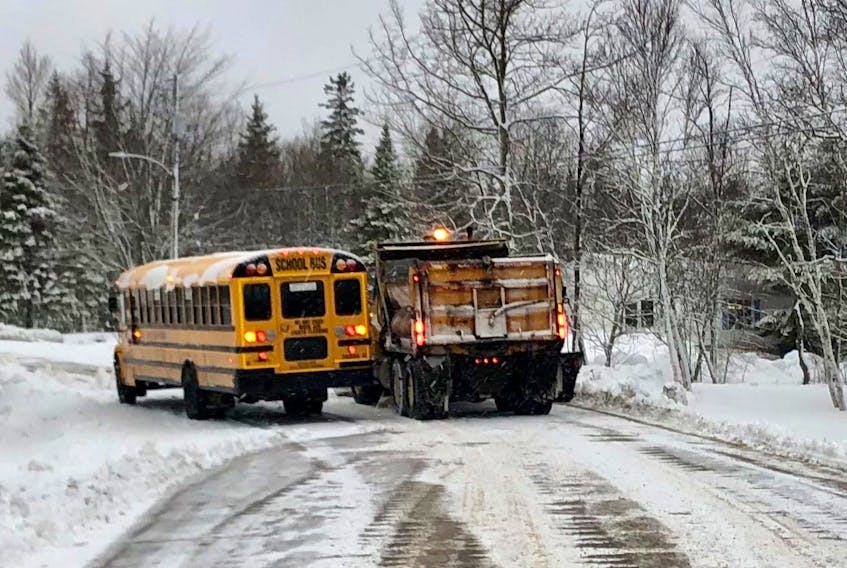 A school bus heading to the Etoile de l'Acadie school in Sydney gets some help from a snowplow, which also salts and sands the roads, after getting stuck off of Mountain Road in Coxheath Tuesday morning. Icy roads caused the bus to get stuck near the start of its route and the five students on board were able to get rides with parents. Some buses with the Cape Breton-Victoria Centre for Education were also delayed and routes on some dirt roads were cancelled for the morning as a snowfall turned to rain and led to slush-covered icy roads in Cape Breton. NICOLE SULLIVAN • CAPE BRETON POST 