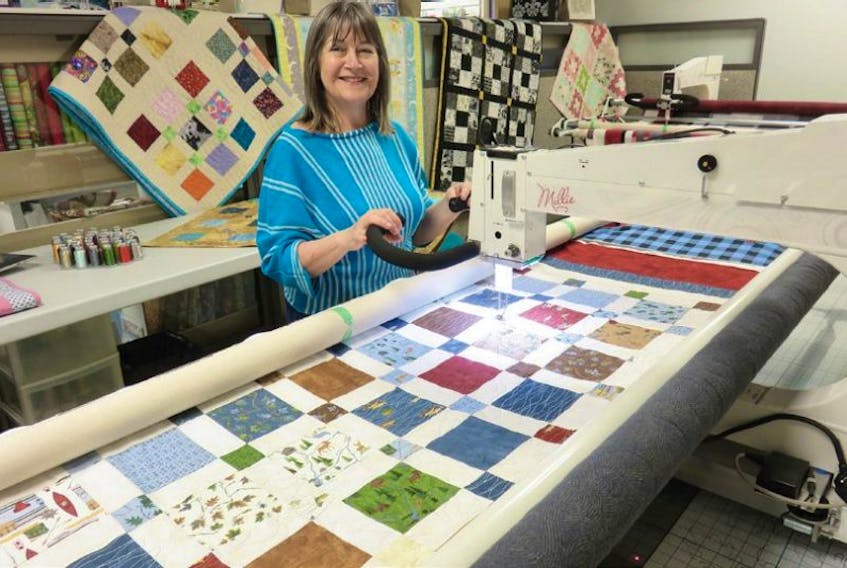 Debbie Northover is shown with the “Millie” long-arm quilting machine by APQS. Sew Many Stitches offers quilting lessons on this machine and does take bookings for rentals.
