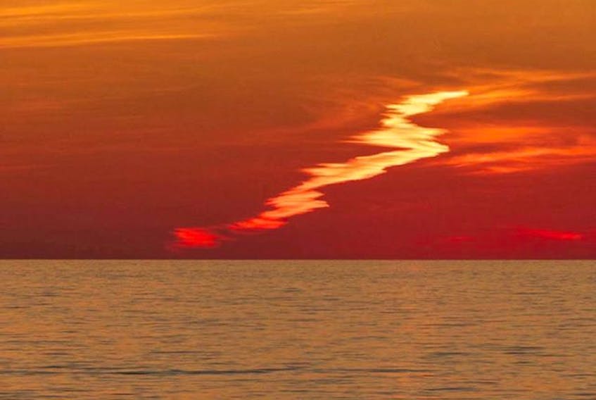 It looks like a tangerine sky to me! They certainly see their share of gorgeous sunsets in Cheticamp N.S. Maurice Deveau captured this unique cloud streak reflecting Mother's Nature brilliant palette as the sun dipped below the horizon.