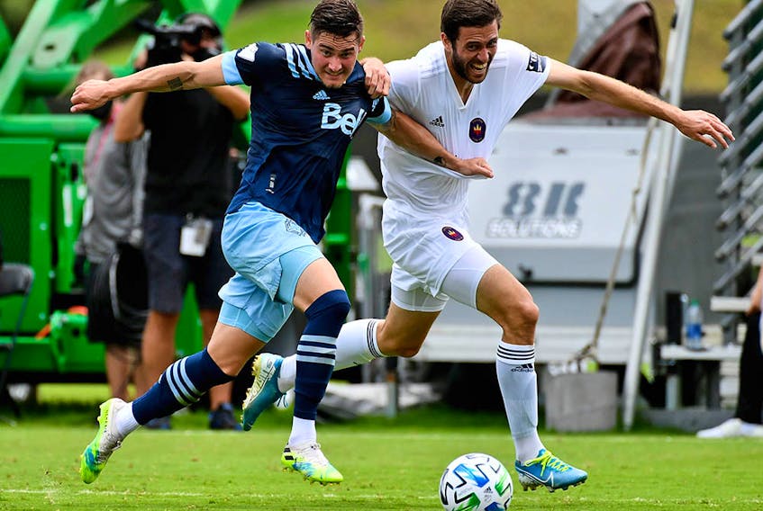 Vancouver Whitecaps defender Jake Nerwinski (28) and Chicago Fire forward Elliot Collier (28) chase a loose ball during the second half at the MLS is Back tournament in Florida.