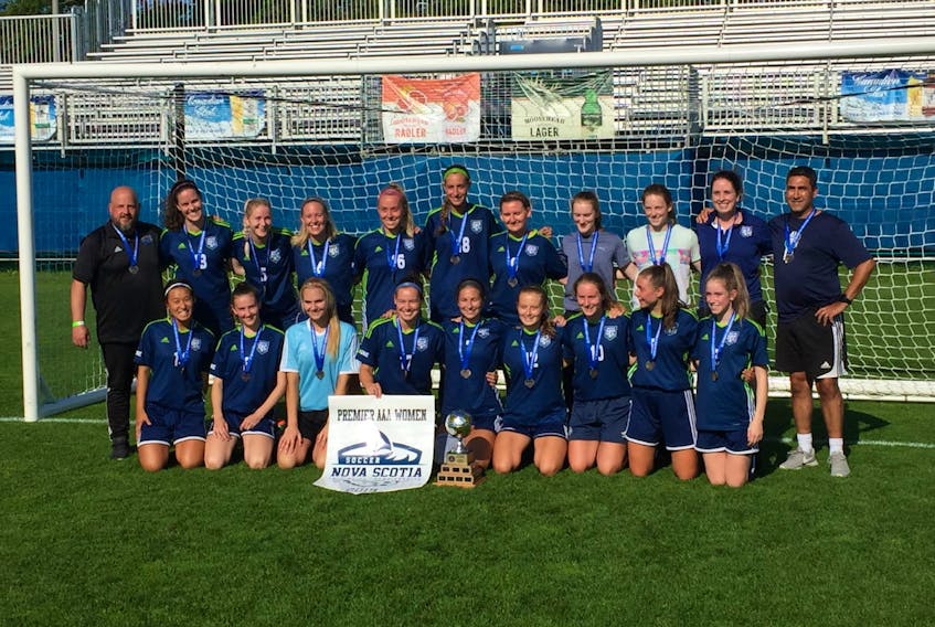 Members of United Dartmouth FC pose with the NSSL Premier league banner and trophy after winning the title Saturday at the Wanderers Grounds in Halifax.