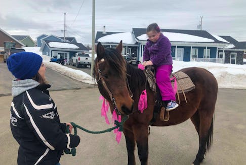 Tara Rowsell, left, stopped by to take birthday girl Claire Sheppard for a ride on her horse. Claire, who turned seven on March 23, was surprised by family friends with a motorcade led by RCMP for her birthday. CONTRIBUTED