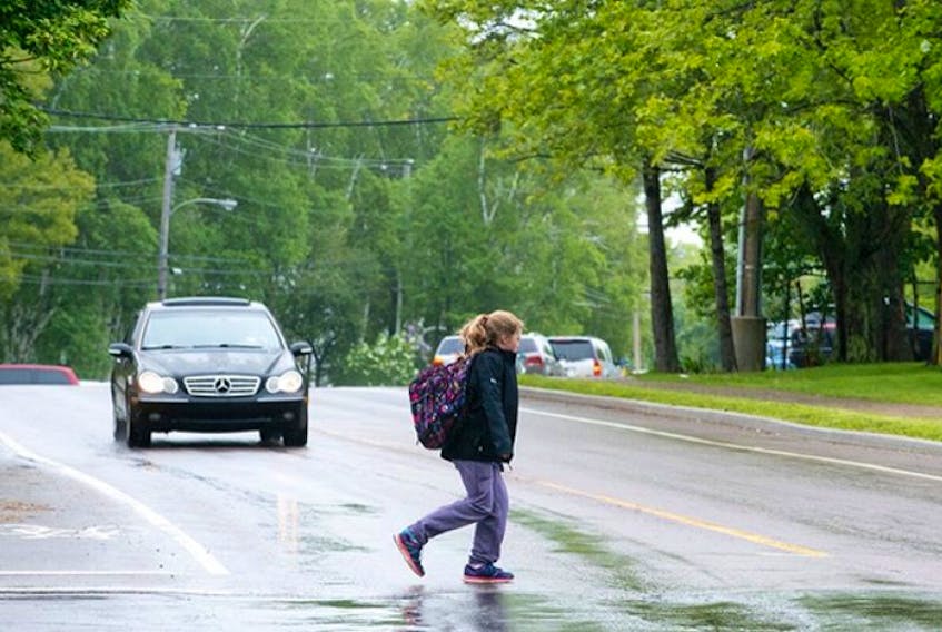 A young girl crosses North River Road on the corner of McGill Avenue Wednesday.