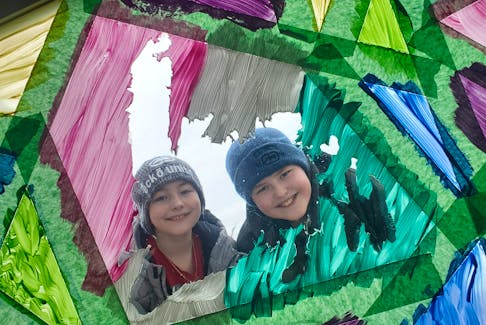 Eric Cooper, left, and his brother Kenneth Cooper display their window painting  in Torbay as part of the NL Easter Egg Hunt 2020 with Social Distancing Facebook group.  