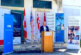 Even a plethora of flags and banners can't hide the worn-out look of the Corner Brook Pulp and Paper Ltd. Human Resources building. However, Premier Dwight Ball, shown speaking in front of the structure on Monday, promised the building will look much different when it opens as a centre for innovation and research for the provincial forest industry.