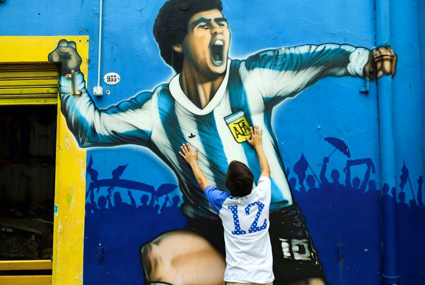 A fan mourns the death of soccer legend Diego Maradona, outside the Alberto J. Armando "La Bombonera" stadium, in Buenos Aires, Argentina, Nov. 25, 2020. 