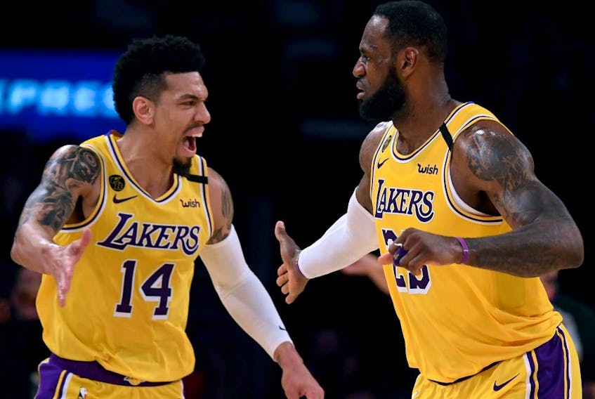 The postponed game between the Los Angeles Lakers and Toronto Raptors, which had been scheduled for Tues. March 24, would have been the only visit by LeBron James (right) to Toronto in the regular season. It also would have featured a championship ring ceremony for former Raptor Danny Green (left). (HARRY HOW/Getty Images)