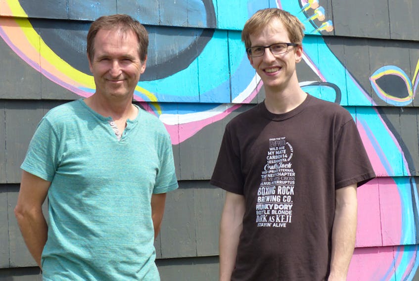 Darcy Rhyno (left) and Alex Buchanan stand in front of the mural at Buchanan’s HarbourTone Productions in Shelburne.