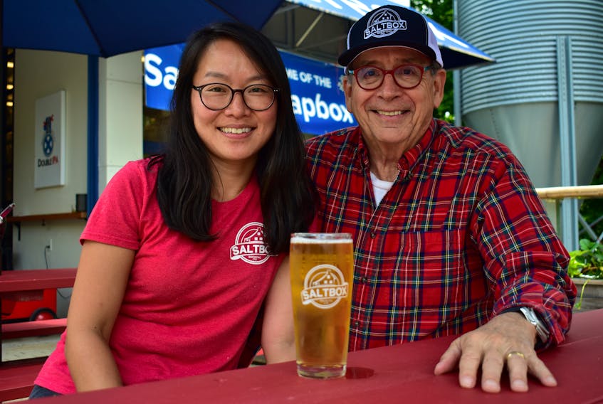 Lina Yang, Saltbox Brewery’s assistant manager, and George Anderson, CEO for the Mahone Bay Brewing Company, pose for a photo at the Saltbox Brewery. Anderson says the company is planning to open a cidery in Lunenburg for next spring.