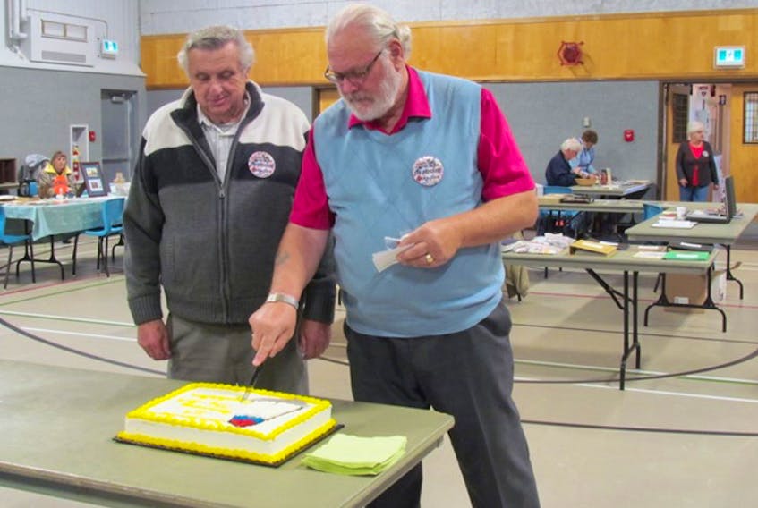 Lloyd Tancock, right, and Charlie Horstman are the only two active members remaining from the original 1994 South Shore Stamp Club. Together, they cut the cake at the club’s 25th anniversary event. - Dawn Corkum photo