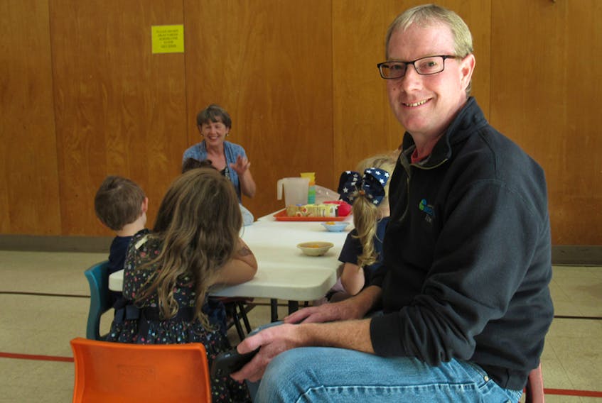 Graham Hopkins visits the Bridgewater Day Care Centre 50 years after he and his twin brother, Gordon, were among the first children to attend the centre. Hopkins sits in a child's chair and reminisces as boys and girls enjoy afternoon snacks. The day care centre is holding a 50-year anniversary open house on Oct. 3.