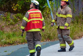 Members of the St. John's Regional Fire Department use portable radios at the scene of a fire at the old West End fire station in October 2020. Telegram File Photo
