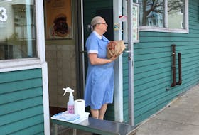 A Ches's Famous Fish and Chips employee leaves an order outside the Freshwater Road location for contactless pickup. — ANDREW ROBINSON/THE TELEGRAM