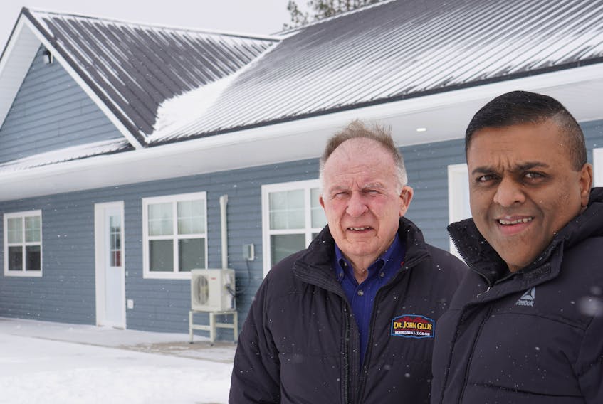 Ajay Mathew Punnapadam, right, and Doug MacKenzie stand outside some of the finished staff housing units for Dr. John M. Gillis Memorial Lodge in Belfast.