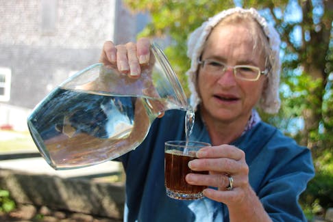 Greta Mossman, senior interpreter, adds water to switchel at the Ross-Thomson House and Store Museum in Shelburne, N.S. Switchel is the 18th-century version of a sports drink.