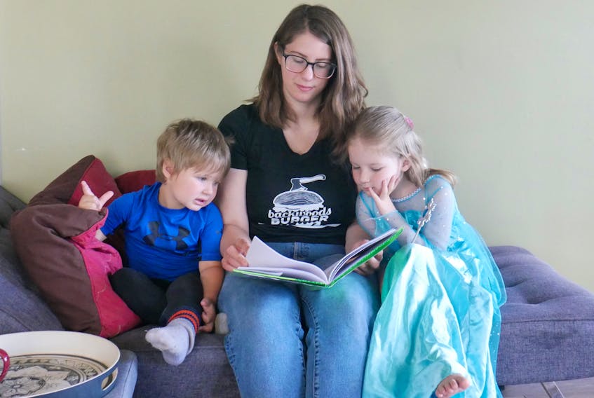 Erica Wagner shares a story with her two little readers, Kaine Ellis, left and Ariya Ellis. 