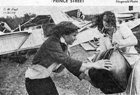 This file photo by Owen Fitzgerald of the devastation of the Oct. 20, 1974, storm made its way to the front pages of newspapers across the country. The unidentified family is shown salvaging what they can after their trailer home was destroyed by wind. <br /><br />