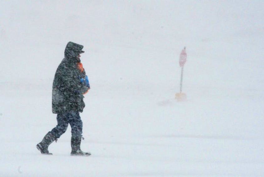 A pedestrian braves the elements as snow continues to fall in St. John's. Environment Canada says the snow will turn to freezing rain and then rain this afternoon in St. John's-metro. — Photo by Keith Gosse/The Telegram