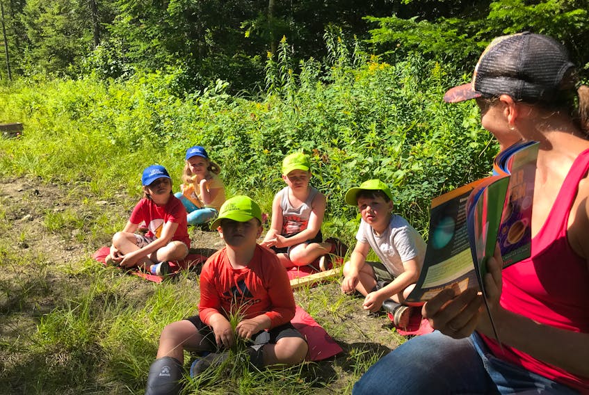 Tamara Reasin, a volunteer with Frontier College, is spending Monday’s in August reading with children in the Sapling Forest School in Corner Brook. From left, (front) Dante Jure and Charlie Howse, and (back) Sloane Sheppard, Ronin Sheppard and Eric Sheppard listen to one of the stories.