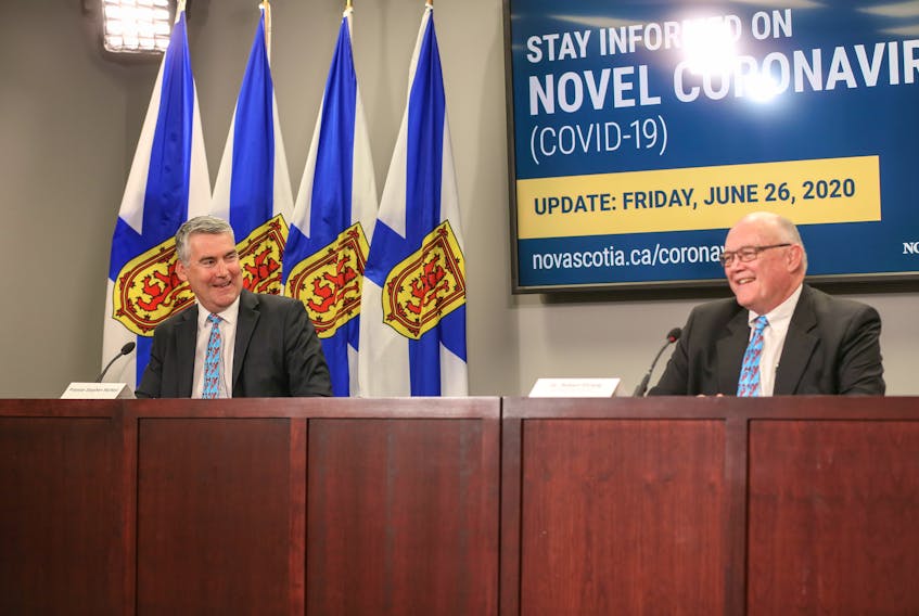 Premier Stephen McNeil and Dr. Robert Strang, Nova Scotia's chief medical officer of health, share a light moment at a news conference Friday talking about their matching ties, which were gifts from Club Inclusion, a centre for people with disabilities in Halifax.