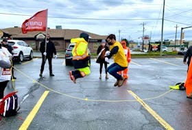 Striking Dominion workers Charlene Rodgers (left) and Jenna Martin (right) spin a rope as Tina Tricco and Michael Tucker jump during a fun moment at a demonstration at No Frills supermarket parking lot in Paradise Thursday morning. More than 100 Dominion workers turned out for the rally, in which they used the rope to form a "human chain of hope and solidarity." – ROSIE MULLALEY/THE TELEGRAM