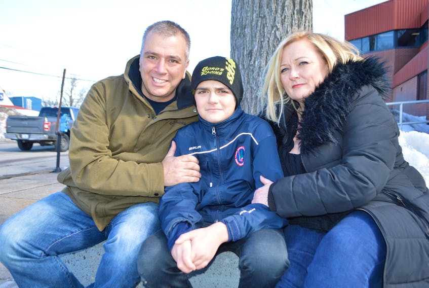 Chase MacNeil, 14, centre, who was violently attacked at Riverview High School Wednesday in an incident caught on video, relaxes in Sydney on Friday with his parents, father Craig MacNeil, of Howie Centre and mother Tricia MacNeil of Westmount. Chase said he’s still a little upset over the ordeal and is still sore and although doesn’t know yet when he’ll be returning to school, doesn’t feel he’ll be scared to go back as he knows there’s a lot of support out there for him and it’s making him feel good. Sharon Montgomery-Dupe/Cape Breton Post