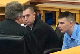 Brandon Glasco (right) and Shane Clarke speak with defence lawyer Tony St. George after the second day of their trial in St. John’s Wednesday. Tara Bradbury/The Telegram