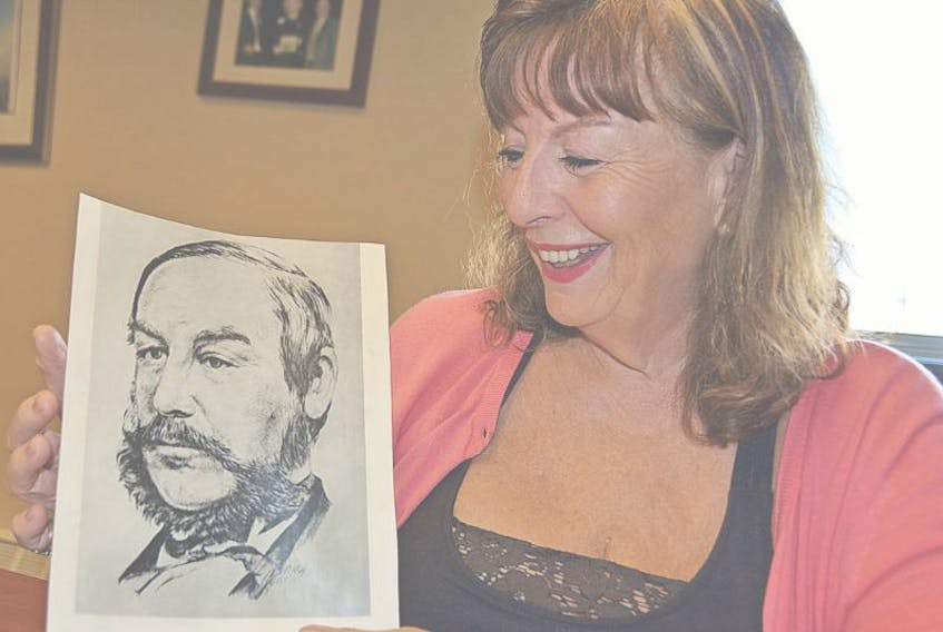 <p>Suzanne Charlton, a descendant of Father of Confederation John Mercer Johnson holds a photo of her famous relative. Colin MacLean/Journal Pioneer&nbsp;</p>