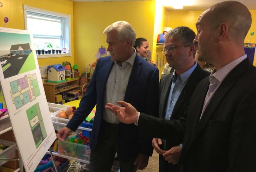 From left, Premier Dwight Ball, Newfoundland Labrador Building and Construction Trades Council executive director Darin King and Early Childhood Development Association vice president Colin O-Brien look over plans for a new childcare facility in Happy Valley-Goose Bay.