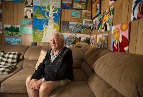 Natan Nevo surrounds himself with colourful artwork at his Clayton Park home. The artwork represents an outlook on life much different than his days hiding in Poland and Serbia.