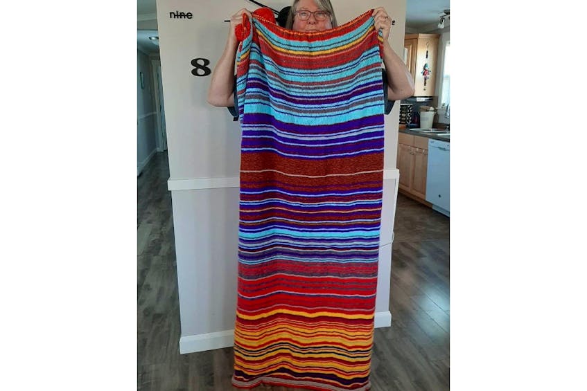 Catherine Montgomery is holding up this year’s temperature blanket – which, of course, is not yet complete. - Wendy Oxley