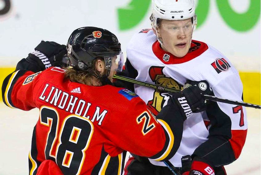 The Senators’ Brady Tkachuk battles against the Calgary Flames’ Elias Lindholm during last week’s game in Calgary. - Al Charest / Postmedia