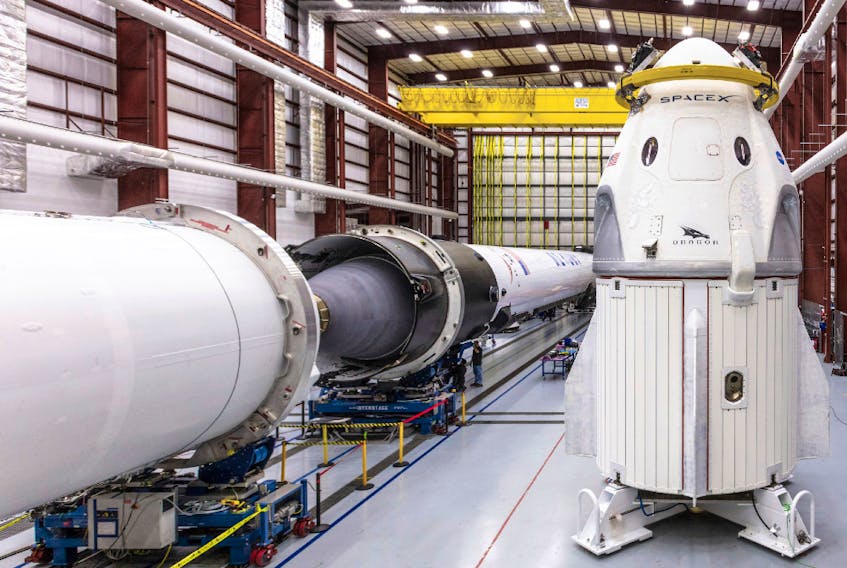 In this Dec. 18, 2018 photo provided by SpaceX, SpaceX's Crew Dragon spacecraft and Falcon 9 rocket are positioned inside the company's hangar at Launch Complex 39A at NASA's Kennedy Space Center in Cape Canaveral, Fla., ahead of the Demo-1 unmanned flight test.