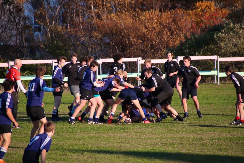 Members of the Gonzaga Vikings (blue) and Holy Heart Highlanders (black) battle it out in the opening game of St. John’s metro high school boys’ rugby this week. Seven boys’ teams and four girls’ teams are set to compete this fall. – Submitted photo