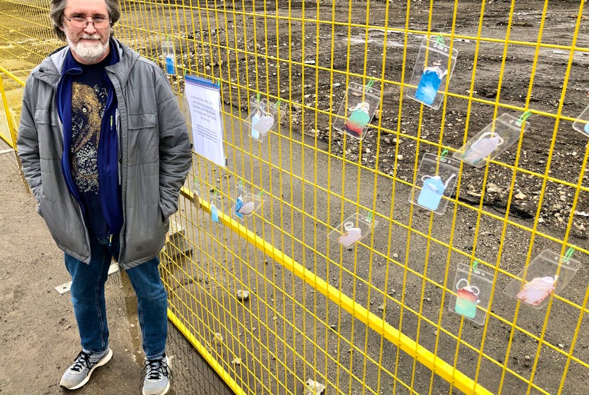 Artist Greg Davies stands next to an installation he erected on Friday in memory of the homeless person who was found dead in a derelict building in Sydney. The building is now demolished. NICOLE SULLIVAN/CAPE BRETON POST 