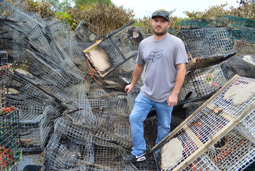Justin Forrest of Crescent Street, Sydney Mines, stands by a huge pile of his lobster traps destroyed in a fire Sunday afternoon. Forrest lost three-quarters of the 300 traps he had. Sharon Montgomery-Dupe/Cape Breton Post
