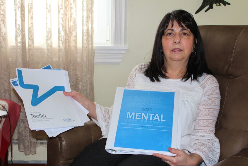 Norma Blinkhorn, co-ordinator of the youth ministry with the Diocese of Antigonish, holds some of the materials that she is using as she prepares for a community conversation about mental illness in youth to take place on Wednesday from 7-8:30 p.m. at Holy Family Parish Hall, Sydney Mines. Nancy King/Cape Breton Post
