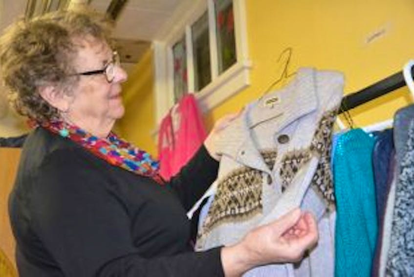 ['<p>Heather Johnston with the Syria to Summerside group arranges clothing that has been donated to support Syrian families that will soon be coming to the city.</p>']