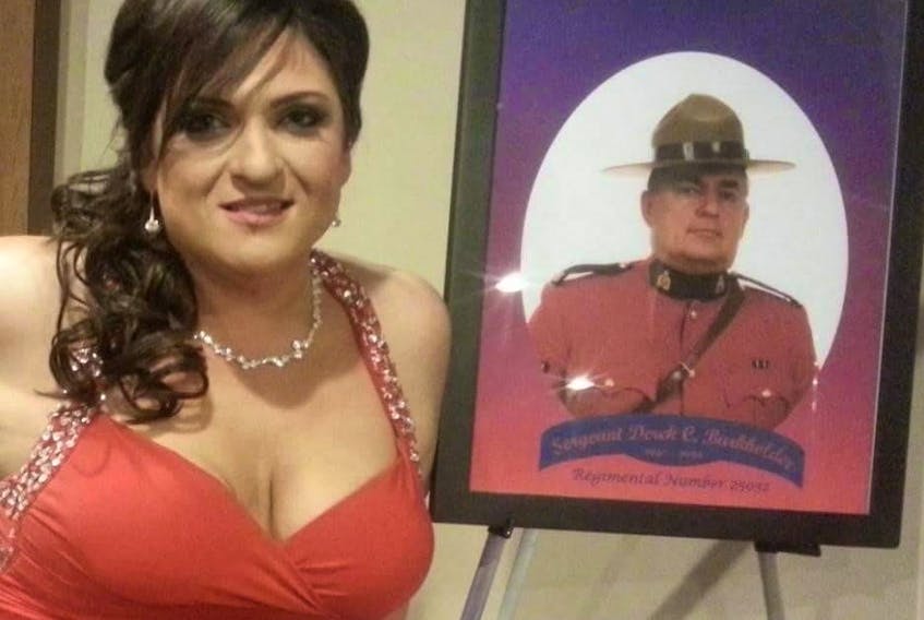 Tanya Burkholder poses with a photo of her father, RCMP Sgt. Derek Burkholder, at a ceremony to recognize his public service. Sgt. Burkholder was killed on a police call in 1996.