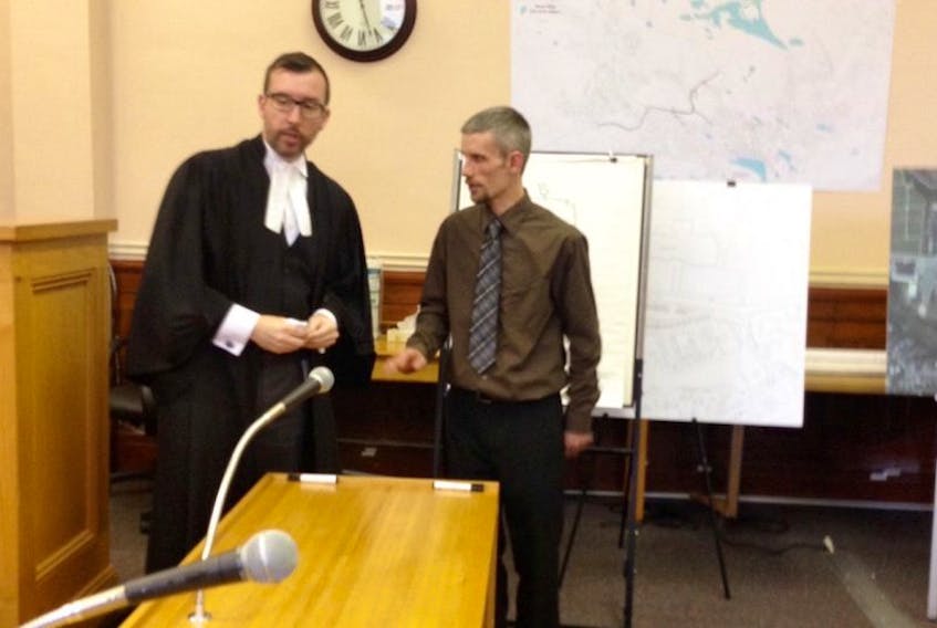 Travis Kean speaks to crown prosecutor Phil LeFeuvre during a break in proceedings Thursday, the first day of testimony in Ray Stacy's second-degree murder trial at Newfoundland Supreme Court in St. John's.