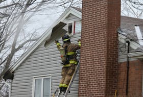 FOR NEWS STANDALONE:
A Halifax regional firefighter tosses a piece of siding while seeking hotspots following a fire in a Penhorn Drive home in Dartmouth Thursday January 14, 2021. Firefighters responded to the call At approx. 2;20 pm in the single-family home and knocked it down quickly. One person assessed by paramedics but not transported. 

TIM KROCHAK PHOTO