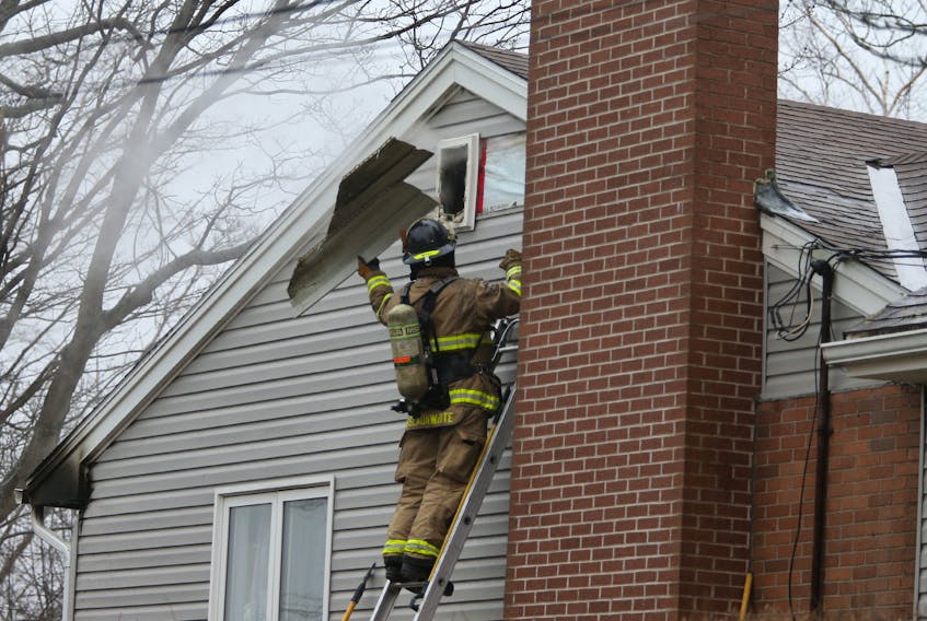FOR NEWS STANDALONE:
A Halifax regional firefighter tosses a piece of siding while seeking hotspots following a fire in a Penhorn Drive home in Dartmouth Thursday January 14, 2021. Firefighters responded to the call At approx. 2;20 pm in the single-family home and knocked it down quickly. One person assessed by paramedics but not transported. 

TIM KROCHAK PHOTO