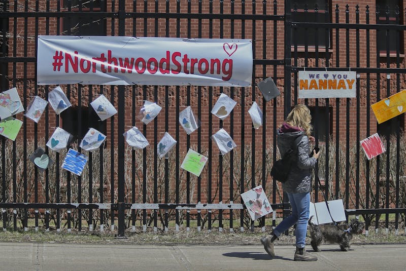 A woman walks past messages of support for residents and staff at Northwood placed across the street of the retirement and care facility in Halifax Wednesday May 6, 2020. - Tim Krochak