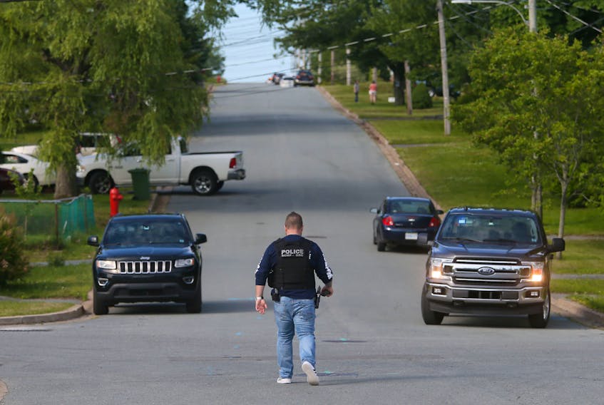 A plainclothes RCMP officer walks up Howard Avenue following a police-involved shooting that claimed the life of a 60-year-old man in Eastern Passage on Thursday.