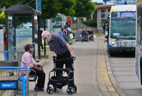 Bus commuters chat, as they await their Metro Transit bus to leave the Mumford Terminal in Halifax Thursday July 9, 2020.